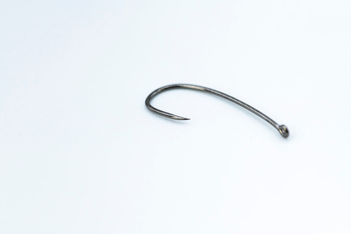 Close-up of a Firehole 718 barbless hook, showing a sharp point with no barb.