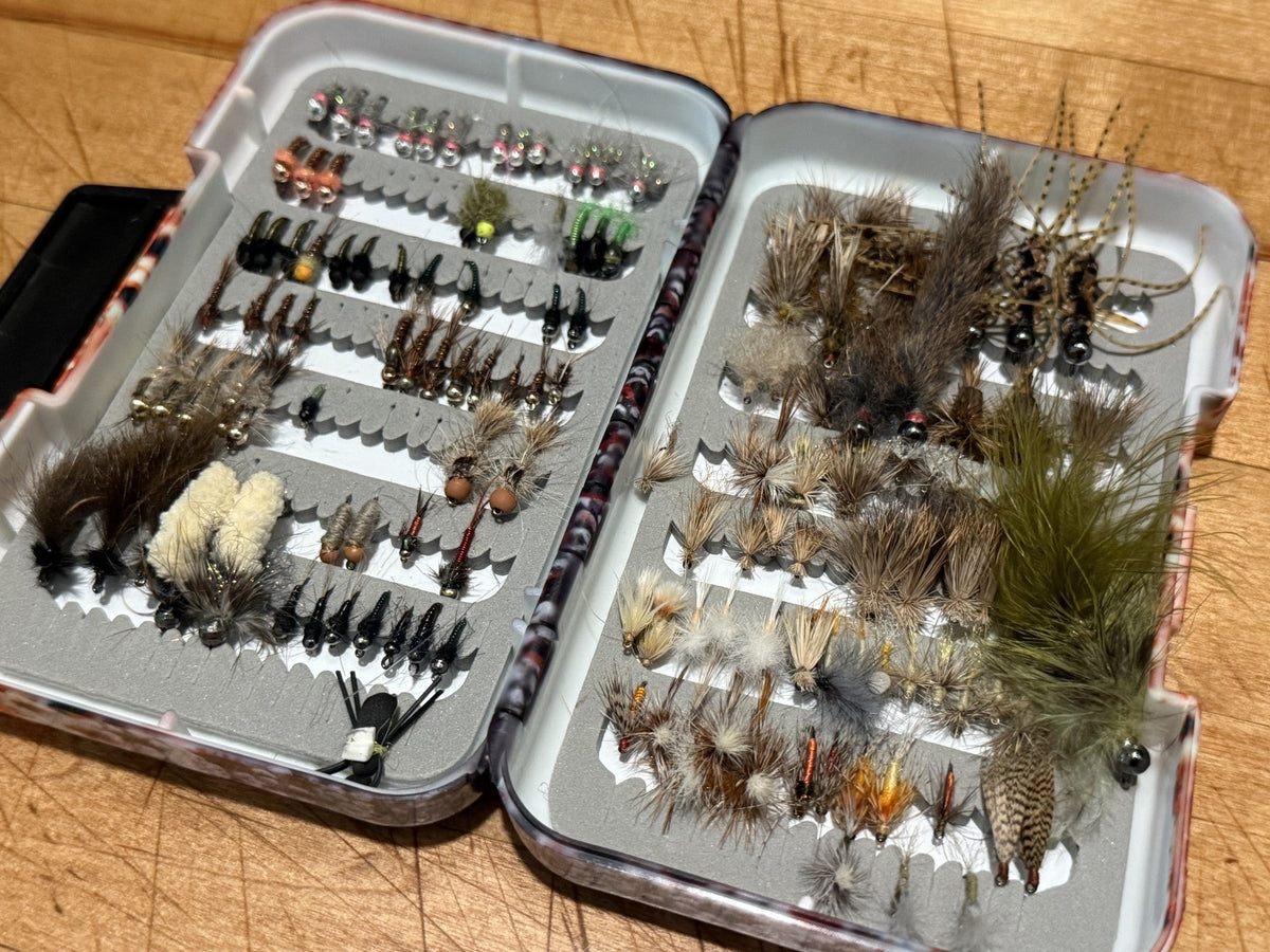 An open fly box with bare foam slots where nymphs were lost over the spring